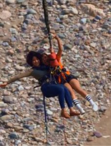 Couple Bungee jumping over a rocky riverbed foradventure in Rishikesh India