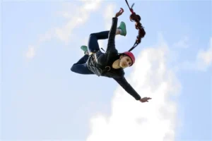 Person bungee jumping against a clear sky during an adventure activity in Rishikesh, India